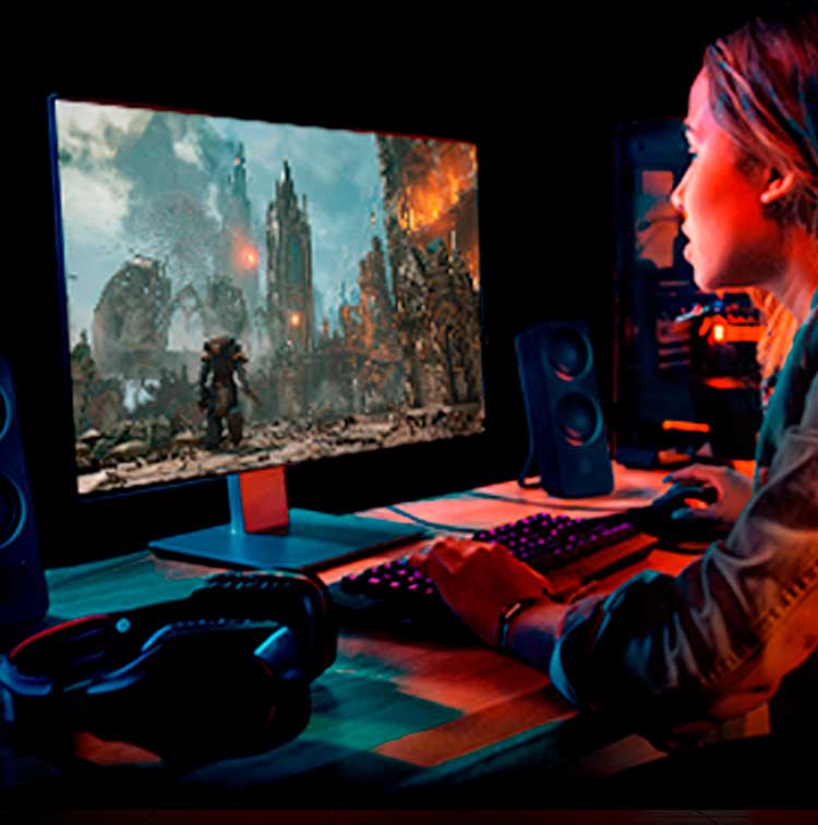 Młody gamer gra w gry akcji na wysokowydajnym monitorze z klawiaturą RGB, głośnikami i headsetem