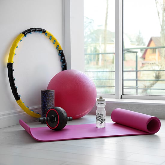 Sprzęt sportowy i fitness Wozinsky z różową matą do jogi, piłką, hula-hop, wałkiem piankowym i bidonem przy oknie